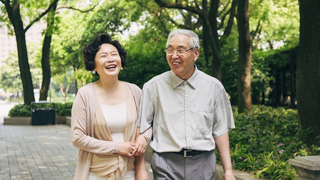mature couple walking in the park and laughing
